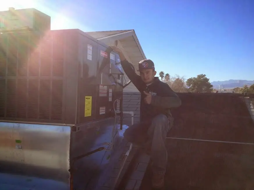 HVAC technician performing Air Duct Cleaning on a rooftop unit in Aspen